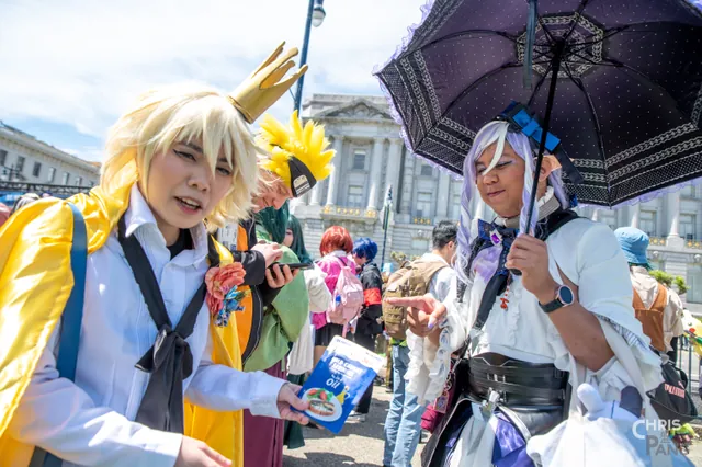 Photo by Christopher Pang / ChrisPang Productions. Two cosplayers outdoors at the NorCal Cherry Blossom Festival cosplay parade, one in white and gold and one in white and blue.